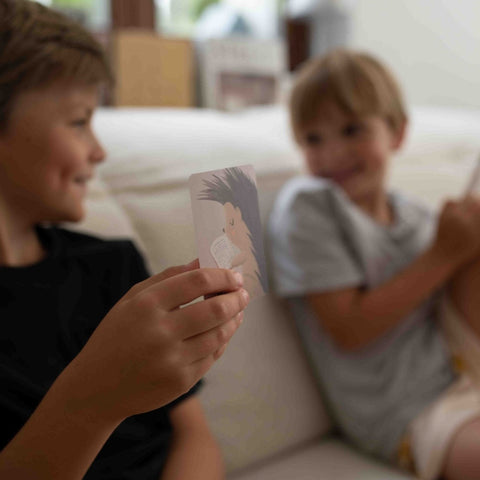 Zwei Jungen unterhalten sich auf dem Sofa über eine Karte